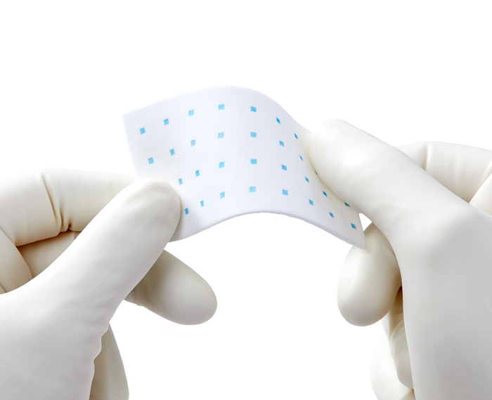 Image of two gloved hands holding Hemopatch product