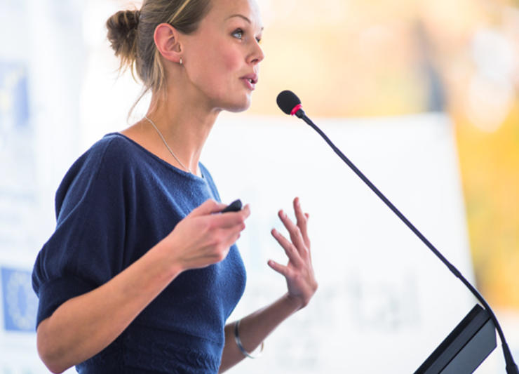 Side image of a female speaker at the podium